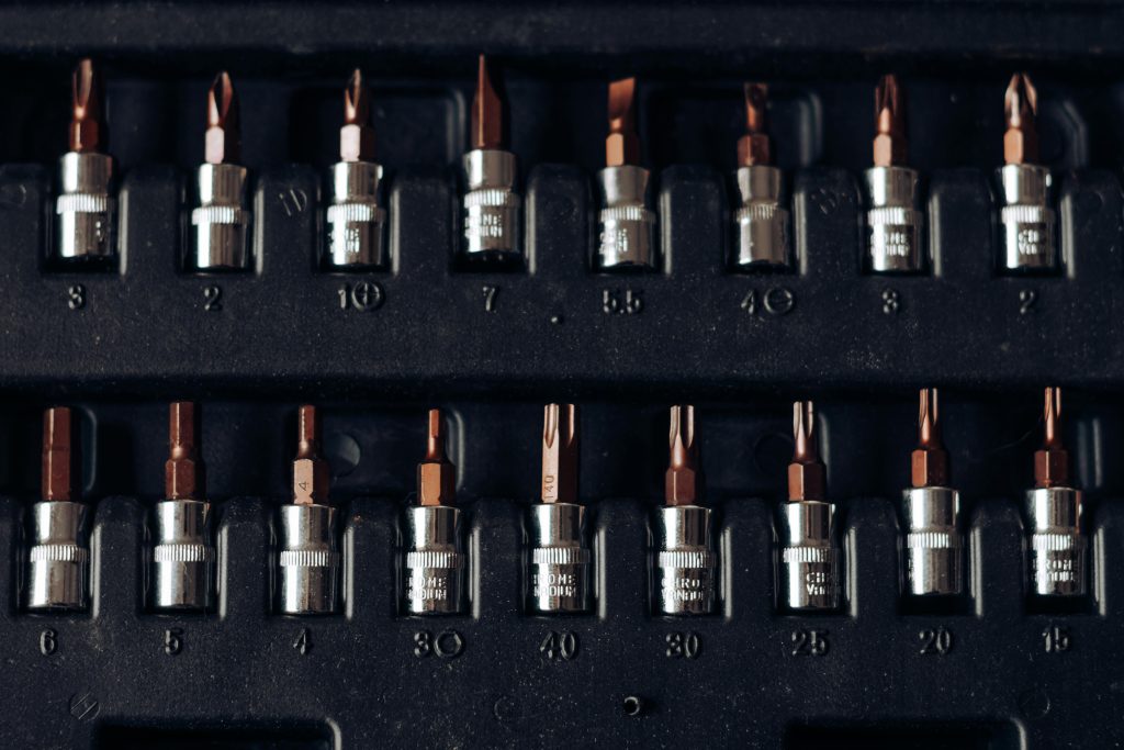 Array of various screwdriver bits in a black casing, ready for use. Assortiment de différents embouts de tournevis dans un étui noir, prêts à l'emploi.