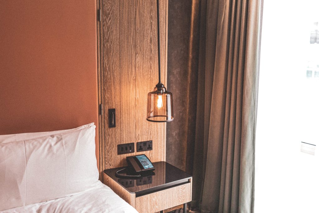 A cozy and modern hotel room featuring minimalist design and warm lighting. Une chambre d'hôtel confortable et moderne avec un design minimaliste et un éclairage chaleureux.