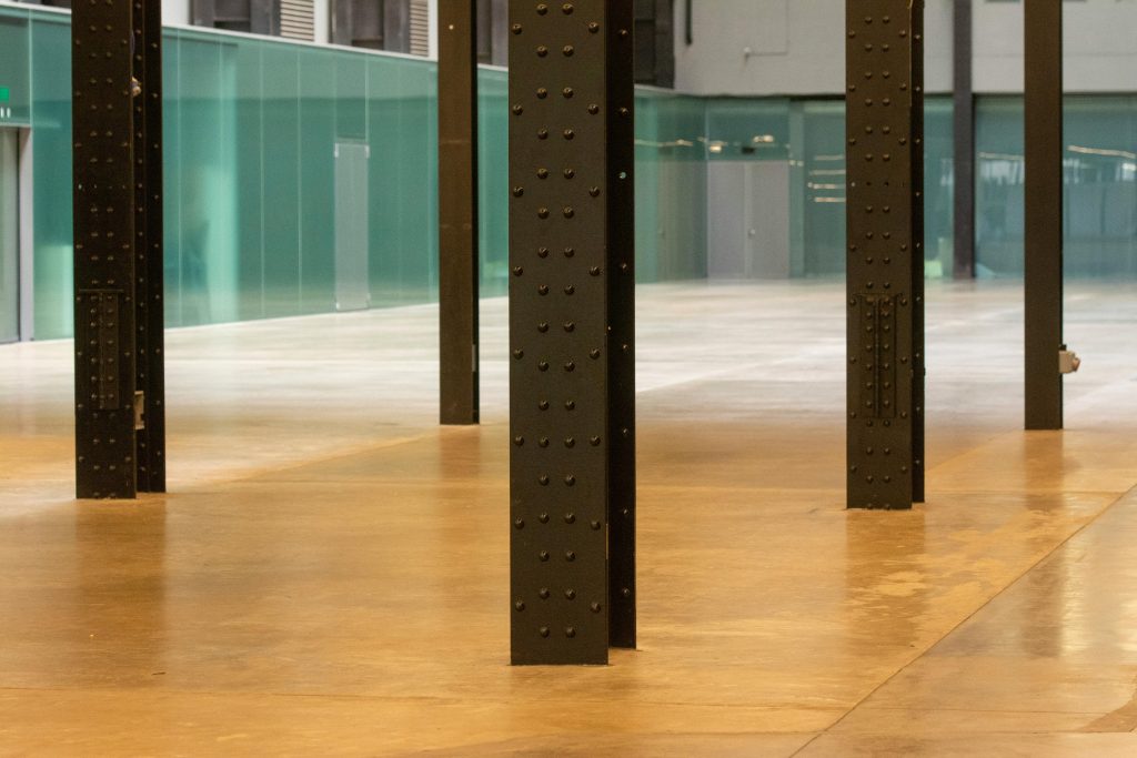 Modern industrial space with steel pillars and a polished concrete floor, perfect for versatile use. Espace industriel moderne avec des piliers en acier et un sol en béton poli, parfait pour un usage polyvalent.