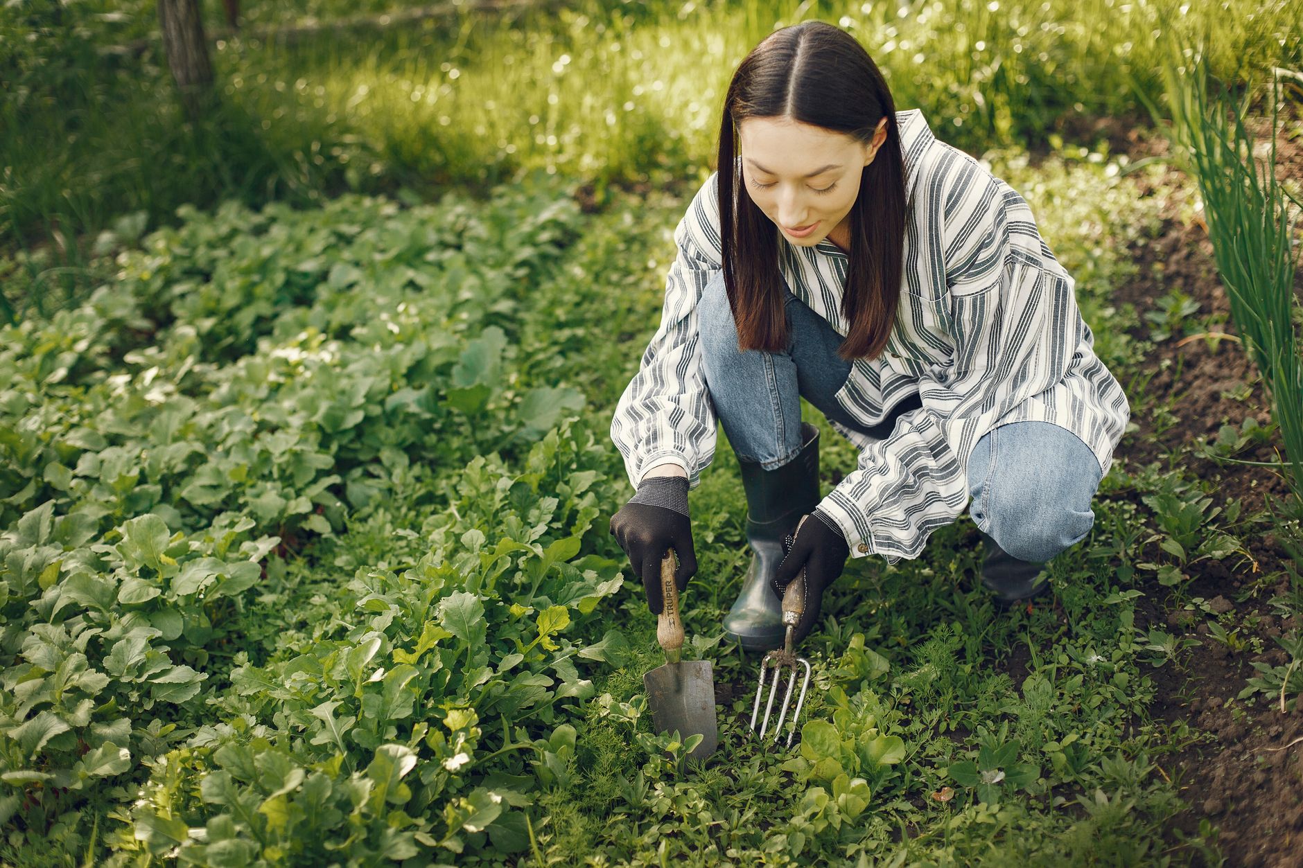 Jardinière entretenant ses massifs avec des outils