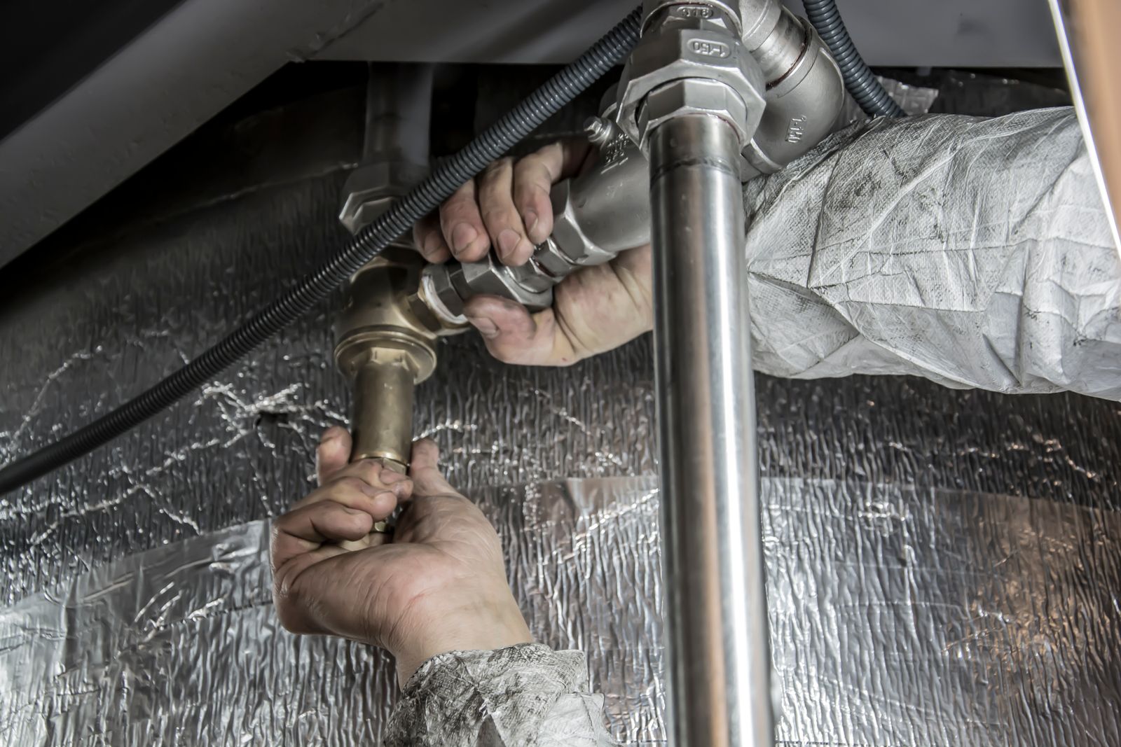 Plombier installant une canalisation en acier