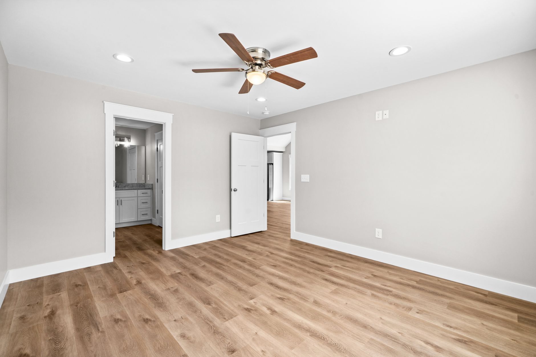 Pièce vide au parquet clair et ventilateur de plafond