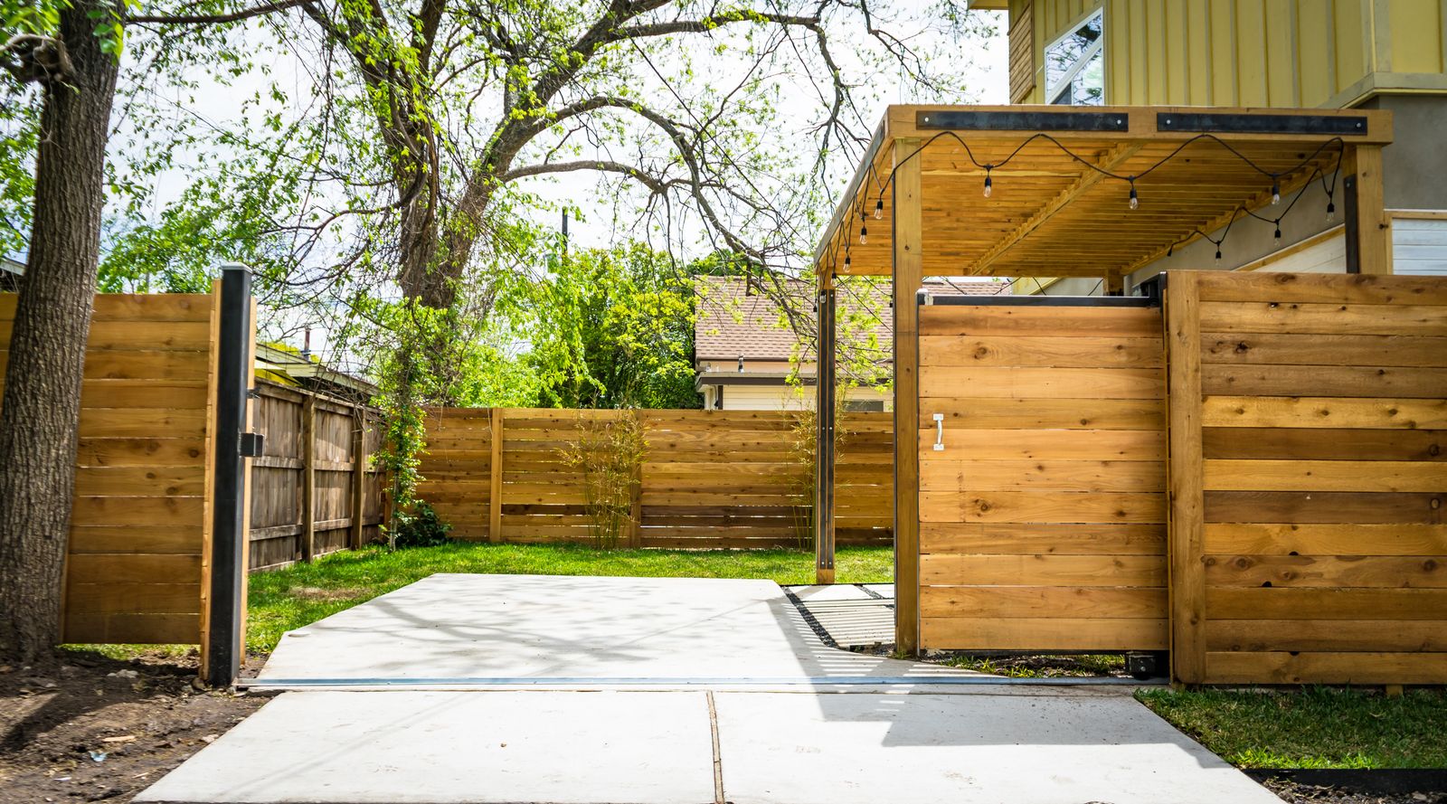 Portail coulissant aux mêmes lames horizontales que la clôture du jardin